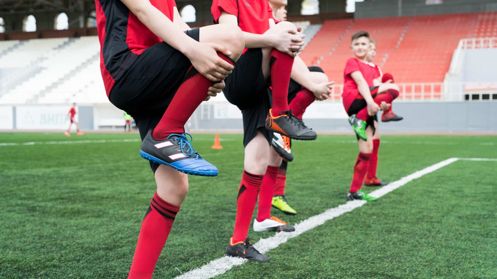 football team using dynamic stretch methods in field
