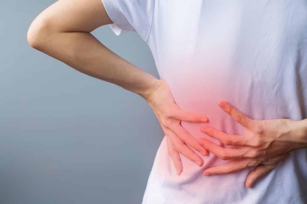 adult female with muscle pain on gray background. elderly woman with degenerative disc disease