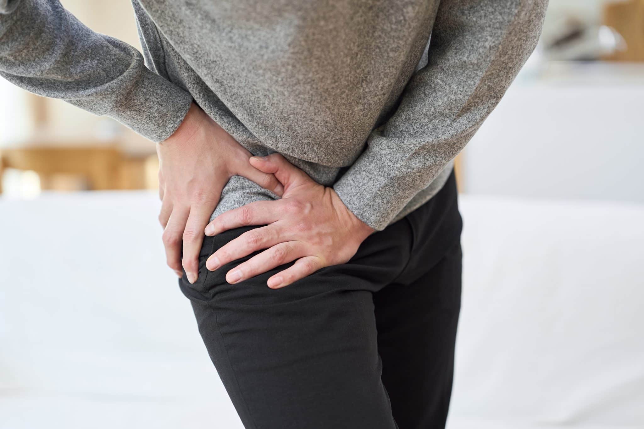 asian man suffering from hip pain