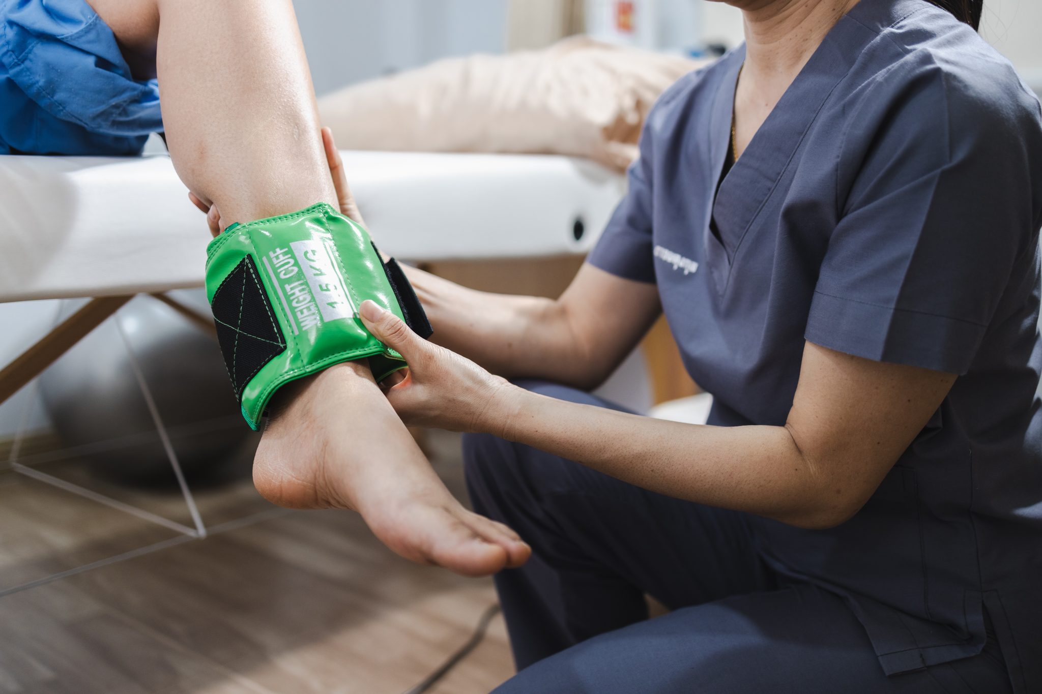 physical therapy, professional providing physical therapy applies treatment device to patient leg, focusing on recovery and rehabilitation. atmosphere is calm and supportive