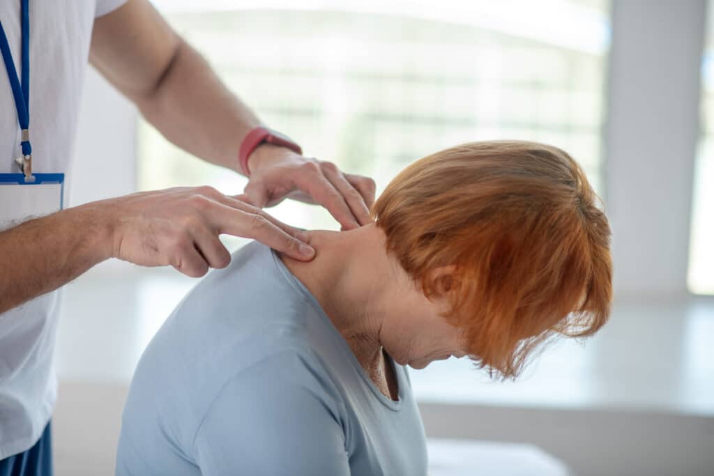 physical therapist guiding a patient through gentle neck mobility exercises