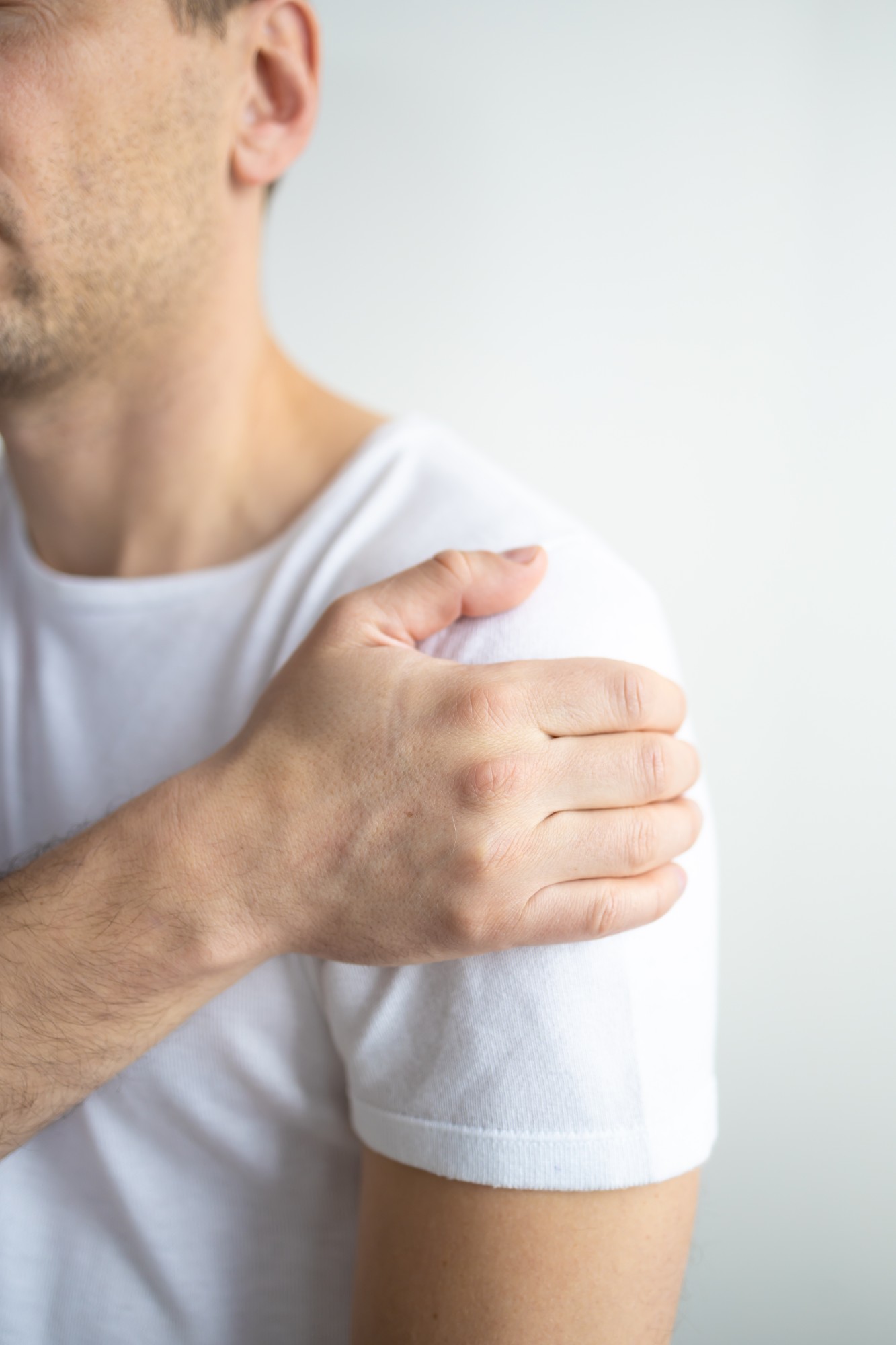 A man holding his painful shoulder